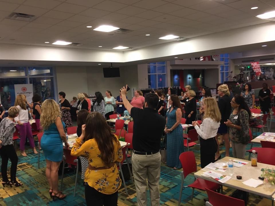 A group standing together during a teambuilding session in a modern event space