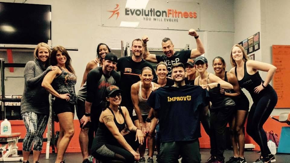 A fitness team posing with an Improv U shirt