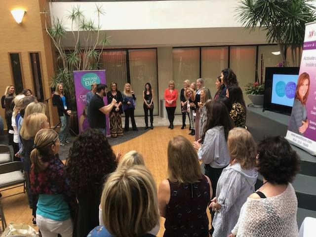 Team members gathered in a circle in an office lobby